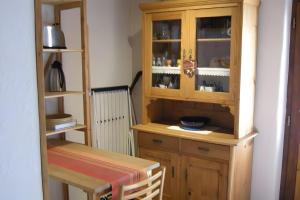 a kitchen with a wooden cabinet and a table at Rhön-Antik in Dipperz