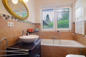 a bathroom with a sink and a tub and a mirror at Ferienwohnung Refugium Schönenberg in Sigmaringen +23 photos