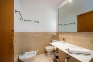 a bathroom with a sink and a toilet and a mirror at Catalina 2b tres dormitorios in Port de Pollensa +25 photos