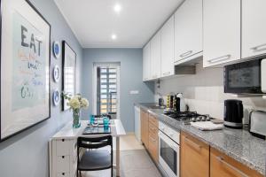 a kitchen with white cabinets and a counter at Apartamento Royal Cabanas Golf in Conceição