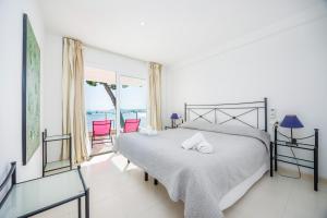 a bedroom with a bed and a view of the ocean at Catalina 2b tres dormitorios in Port de Pollensa