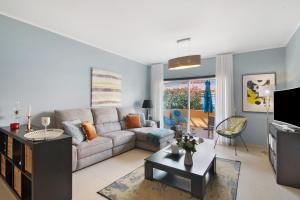 a living room with a couch and a tv at Apartamento Royal Cabanas Golf in Conceição