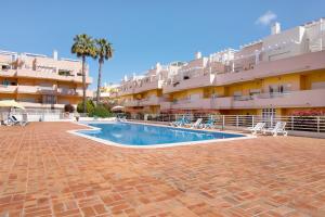 a swimming pool in front of a building at Apartamento Royal Cabanas Golf in Conceição