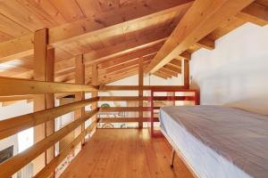 a bedroom with wooden ceilings and a bed in a room at Grace house holiday in San Fedele Intelvi