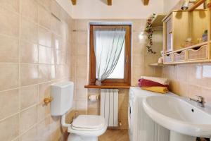 a bathroom with a toilet and a sink and a window at Grace house holiday in San Fedele Intelvi