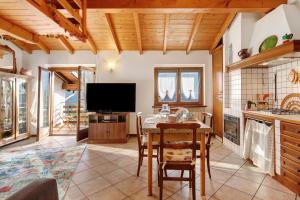a kitchen with a table with chairs and a television at Grace house holiday in San Fedele Intelvi +23 photos