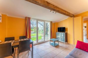 a living room with yellow walls and a table and chairs at Mazet à Nimes in Nîmes