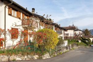 a white house with flowers on the side of it at Grace house holiday in San Fedele Intelvi