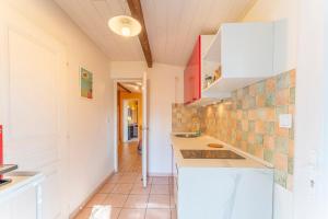 a kitchen with white cabinets and tiles on the wall at Mazet à Nimes in Nîmes +17 photos