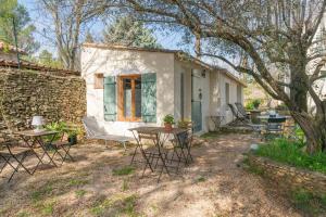 a small white house with chairs and a table at Mazet à Nimes in Nîmes