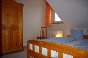 a bedroom with a bed and a window and a chair at Obst- und Ferienhof Schäfler in Hattnau