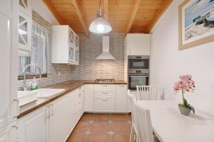 a kitchen with white cabinets and a table with a vase of flowers at Finca Keyfer in Vilaflor