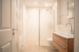 a bathroom with a shower and a toilet and a sink at Flutgold Dangast in Dangast +121 photos