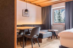 a hotel room with a table and chairs and a bed at La Grambla App Saslonch 1 in Santa Cristina Gherdëina