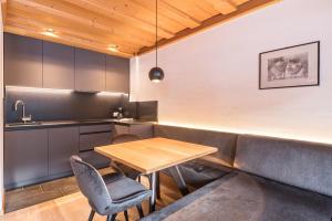 a kitchen with a couch and a wooden table at La Grambla App Saslonch 1 in Santa Cristina Gherdëina +25 photos