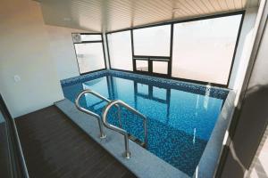 a swimming pool in a building with two metal rails at 포항 이가리 독채 풀빌라 엘리시안 풀빌라펜션 in Pohang