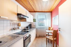 a kitchen with white cabinets and a table with chairs at Gästehaus Gross in Neustadt an der Weinstraße +16 photos