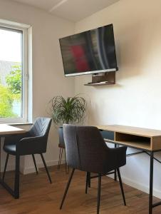 a living room with two chairs and a tv on the wall at Ferienhaus Ahaus in Ahaus +17 photos