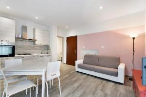 a kitchen and living room with a table and a couch at Sweet Home Apartments Peperoncino in Arona