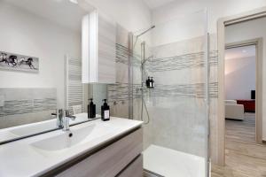 a white bathroom with a sink and a shower at Sweet Home Apartments Peperoncino in Arona +14 photos