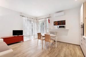 a living room with a table and chairs and a television at Sweet Home Apartments Peperoncino in Arona