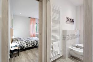 a white bathroom with a bed and a sink at Sweet Home Apartments Peperoncino in Arona