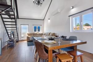 a dining room and living room with a table and chairs at Casa do Canudo in Marinha Grande