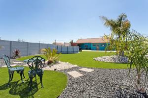 a garden with two chairs and a house at Casa do Canudo in Marinha Grande