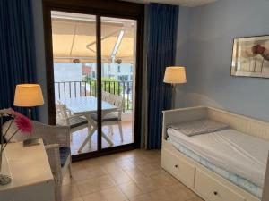 a bedroom with a bed and a balcony with a table at Sunny apartment with pool in Tossa de Mar