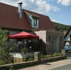 a house with a red umbrella and a table at Zauberhaftes Franken erleben in Gräfendorf
