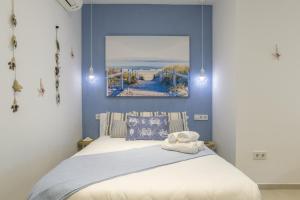 a bedroom with a bed with a blue wall at Apartamento Tarifa Dream B 08 in Tarifa +17 photos
