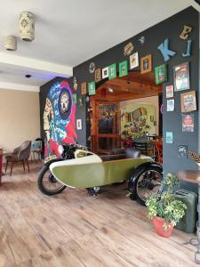 a room with a motorcycle with a surfboard on it at Hikers & Bikers in Haripūr
