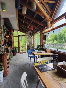 a restaurant with wooden tables and chairs and windows at Hikers & Bikers in Haripūr
