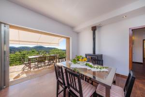 a dining room with a table and a balcony at Finca Bionic in Artá