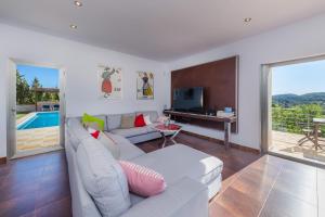 a living room with a white couch and a television at Finca Bionic in Artá