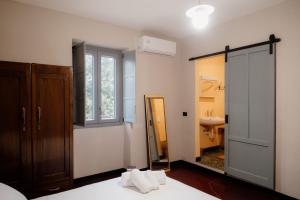 a bedroom with a mirror and a bathroom with a sink at Beb La Patataia Home in Bormida