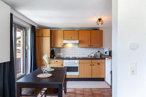a kitchen with wooden cabinets and a black table at Feichtenhäusl app 1 in Westendorf