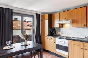a kitchen with wooden cabinets and a table and a window at Feichtenhäusl app 1 in Westendorf +21 photos