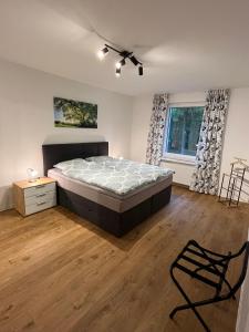 ein Schlafzimmer mit einem Bett und einem Stuhl in der Unterkunft Seeterrasse in Versmold