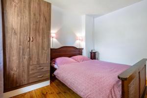 a bedroom with a bed and a large wooden cabinet at Ferienwohnung Halunder in Leck