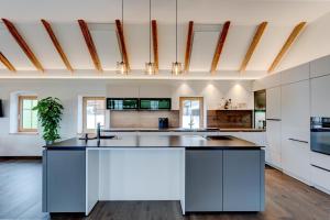 an open kitchen with white cabinets and a large island at Außergewöhnliches Loft Senftenbach in Senftenbach