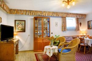 a living room with a tv and a table at Ferienwohnungen Landhaus Strell in Bad Griesbach