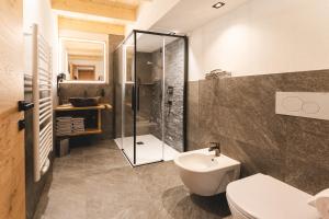a bathroom with a shower and a toilet and a sink at Egorta - Egarterhof Sexten in Sesto +41 photos