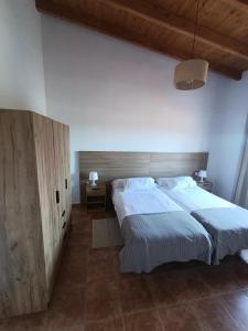 a bedroom with two beds and a wooden headboard at Casas Quemahierro in Icod de los Vinos