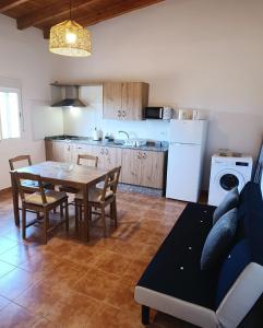 a living room with a table and a kitchen at Casas Quemahierro in Icod de los Vinos
