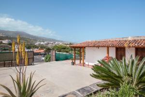 a house with a patio with a mountain in the background at Casas Quemahierro in Icod de los Vinos