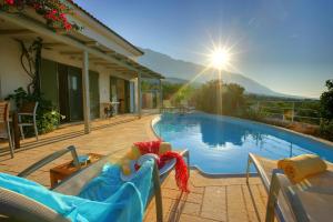 a swimming pool with chairs and a swimming pool at Villa Petalida Ideales Resort in Kefallonia