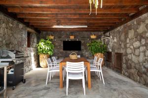 a dining room with a wooden table and white chairs at Finca El Refugio in Teguise