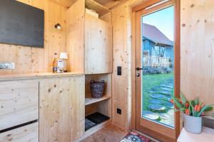 Eine Holzhütte mit Fernseher und Fenster in der Unterkunft Tiny Houses der Dorfscheune in Bieselberg