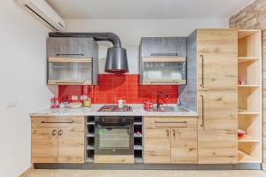 a kitchen with wooden cabinets and a sink at Casa Castro Vista Grotta in Castro di Lecce